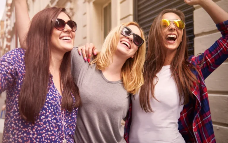 Three friends walking happy together, showing women's wellness with friends